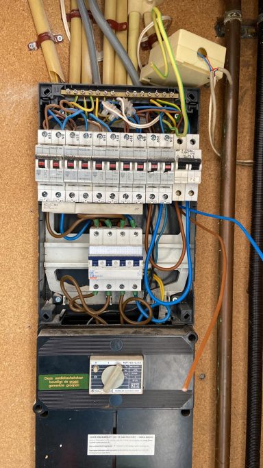 Kast met elektrische bedrading en een verdeelkast met zekeringen en aansluitingen.